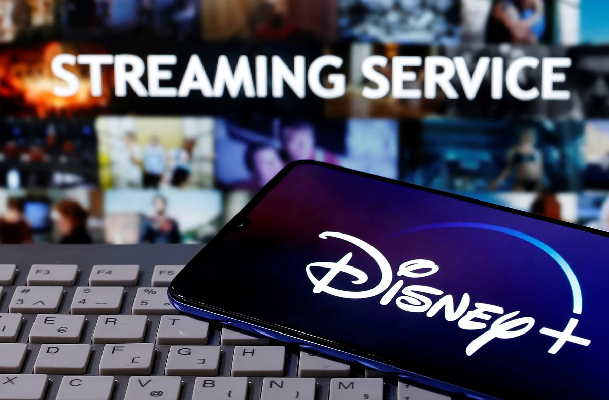 A smartphone with displayed "Disney" logo is seen on the keyboard in front of displayed "Streaming service" words in this illustration taken 24 March 2020.