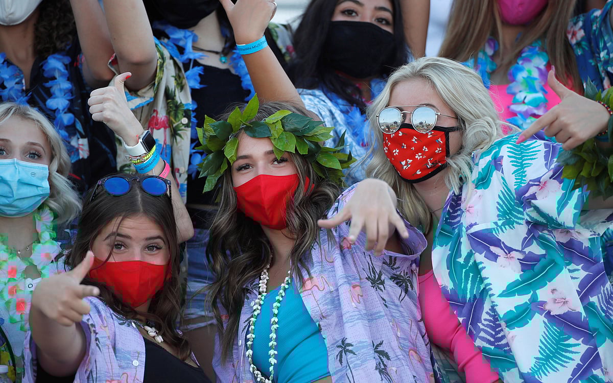 Masked fans cheer during the game between the Herriman Mustangs and Davis Darts high school teams during a game between the two high school teams, the first regular season football game in the United States since the coronavirus disease (COVID-19) pandemic began, at Herriman High School in Herriman, Utah, US 13 August 2020