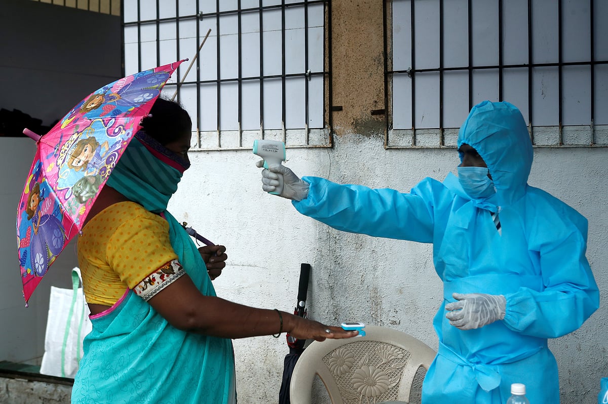 A healthcare worker checks the temperature and pulse of a resident during a check-up camp for the coronavirus disease (COVID-19), in Mumbai, India, 4 July 2020.