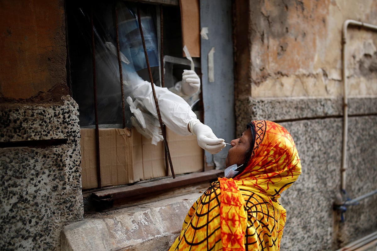 A health worker in personal protective equipment (PPE) collects a sample using a swab from a person at a local health centre to conduct tests for the coronavirus disease (COVID-19), amid the spread of the disease, in the old quarters of Delhi, India, 14 August 2020
