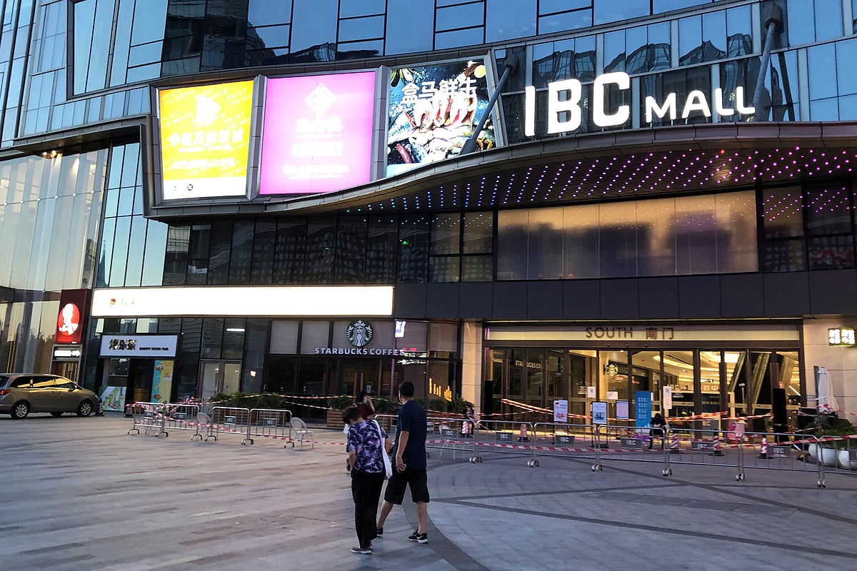 People wearing face masks walk past Shenzhen's IBC Mall, which has been sealed off after a new case of the coronavirus disease (COVID-19) was confirmed, Guangdong, China on 14 August 2020