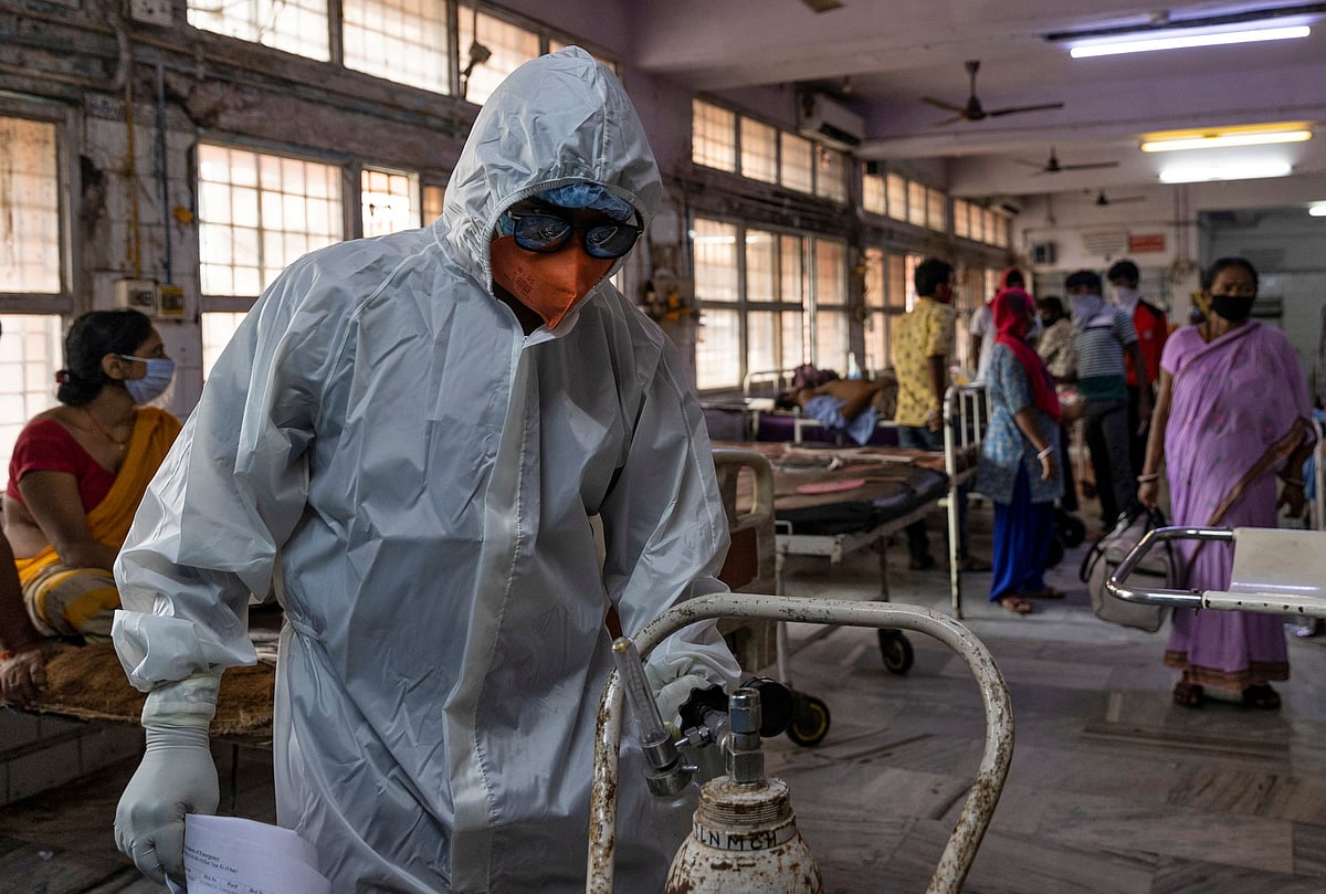 A medical worker, checks an oxygen cylinder before transferring COVID-19 patient from the emergency ward to the Intensive Care Unit (ICU) of Jawahar Lal Nehru Medical College and Hospital, Bihar, India, 27 July 2020.