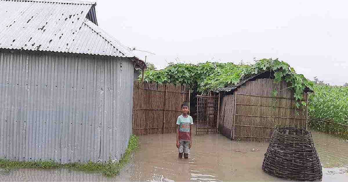 A boy stands in the floodwater