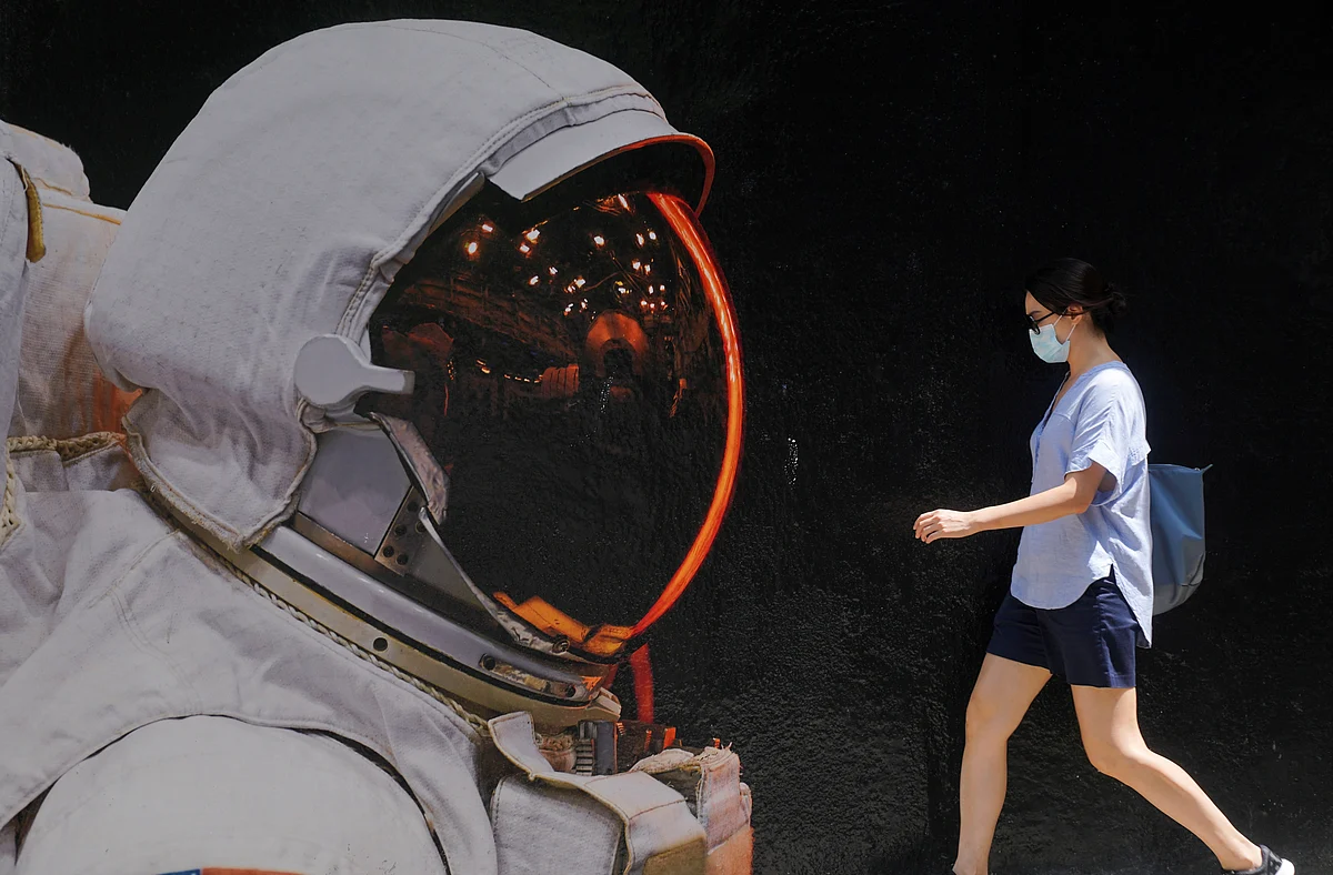 A woman wearing a face mask walks past a mural, following the coronavirus disease (COVID-19) outbreak, in Hong Kong, China, 25 August 2020.