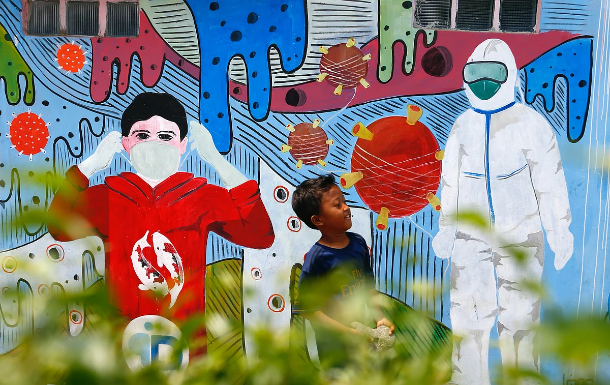 A boy walks near a mural promoting the coronavirus disease (COVID-19) awareness in Depok, on the outskirts of Jakarta, Indonesia, on 11 August 2020.