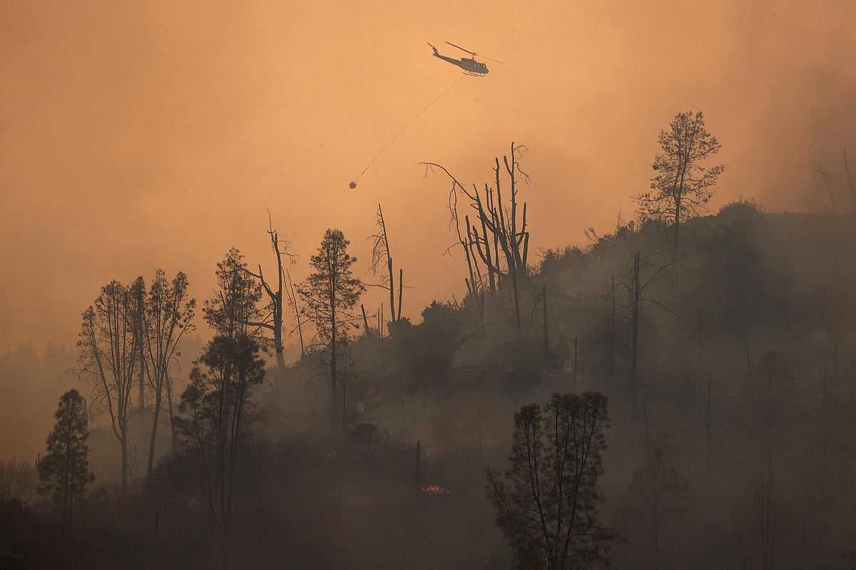 A helicopter and crew releases water to extinguish a section of the LNU Lightning Complex Fire near Middletown, California, US, 24 August 2020.