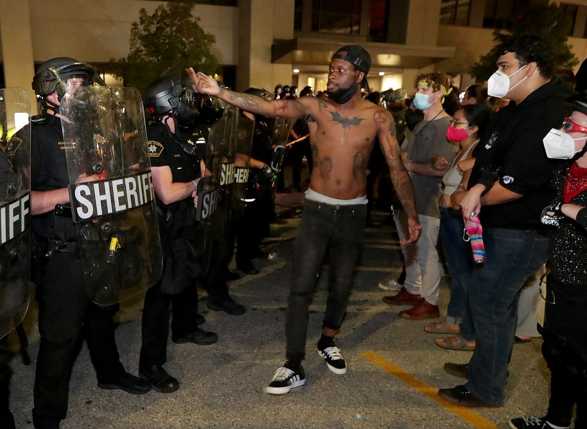 A man confronts police outside the Kenosha Police Department in Kenosha, Wisconsin, U.S., during protests following the police shooting of Black man Jacob Blake 23 August, 2020.