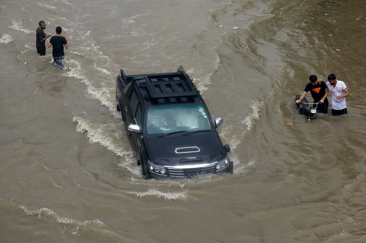 A vehicle passes through the flooded street during monsoon rain, as the outbreak of the coronavirus disease (COVID-19) continues, in Karachi, Pakistan, 27 August 2020.
