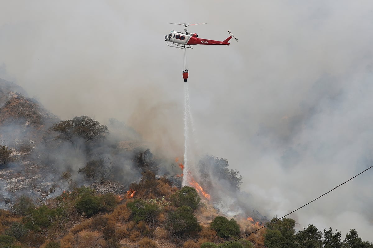 A helicopter drops water to help extinguish the Bobcat Fire, in Arcadia, California, US, 13 September, 2020.