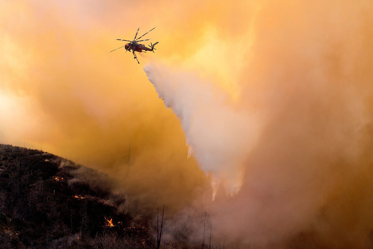 A helicopter makes a water drop over a wildfire in the Angeles National Forest during the Bobcat Fire in Los Angeles, California, US, on 17 September 2020