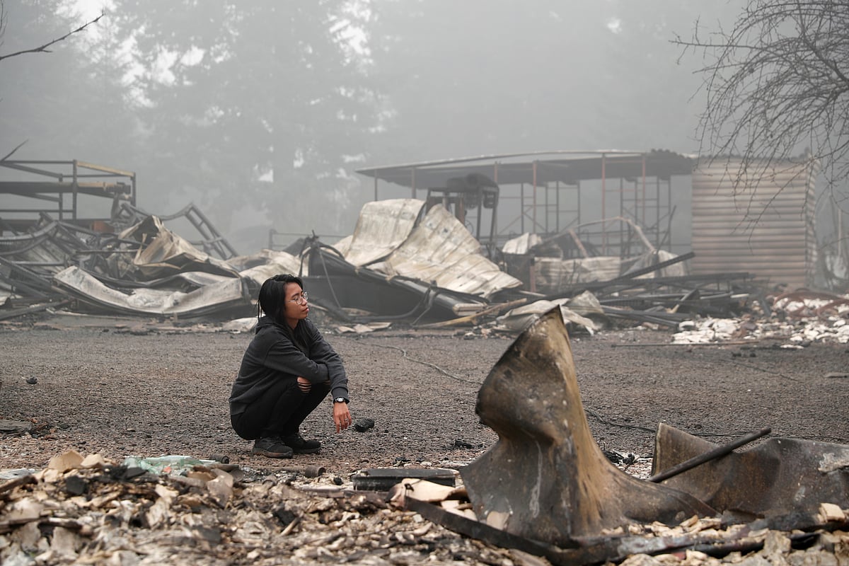 A woman inspects the remains of the burnt down property of her relatives, as the wildfire continues in Estacada, Oregon, US, 13 September 2020.