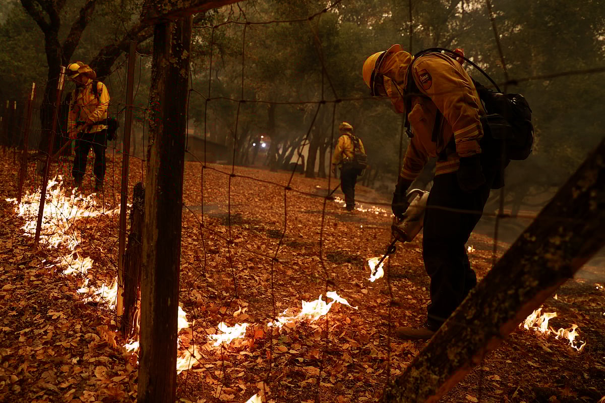 Firefighters with the Cal Fire Sonoma-Lake-Napa Unit (LNU) light a backfire to defend a property during the Glass Incident Fire in Santa Rosa, California, US 28 September 2020