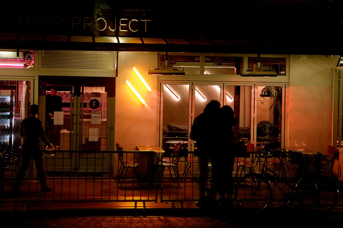 A couple kiss in front of a closing bar in Paris, on October 5, 2020 amid new measures to fight the rapid spread of COVID-19