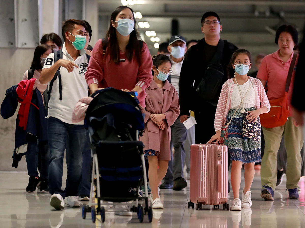 Chinese tourists wear masks as they arrive at Suvarnabhumi Airport during a welcome ceremony of Chinese Lunar New Year travellers in Bangkok, Thailand, 22 January 2020.