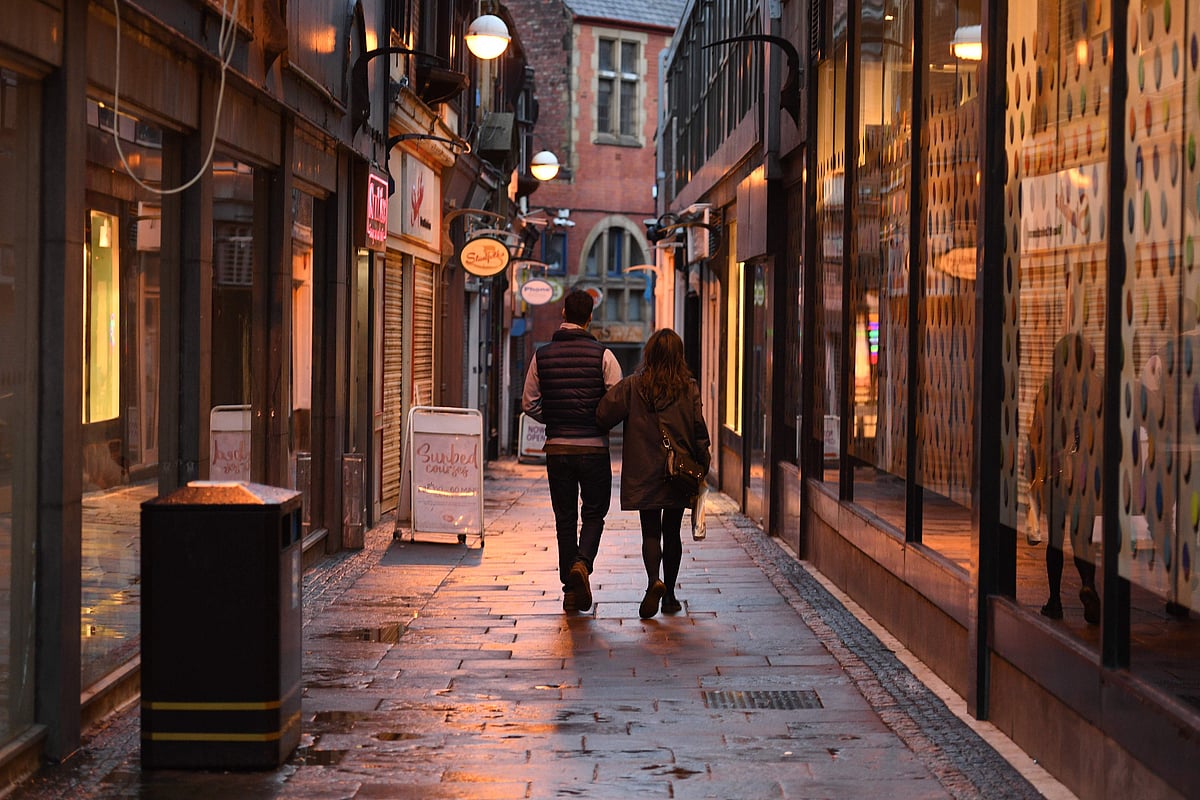 A couple walk past closed shops in a quiet lane in central Sheffield, in northern England on 21 October 2020, prior to further lockdown measures to combat the rise in novel coronavirus COVID-19 cases. More than a million people in northern England will be banned from mixing with other households under tougher new coronavirus rules announced by government minister Robert Jenrick on Wednesday AFP