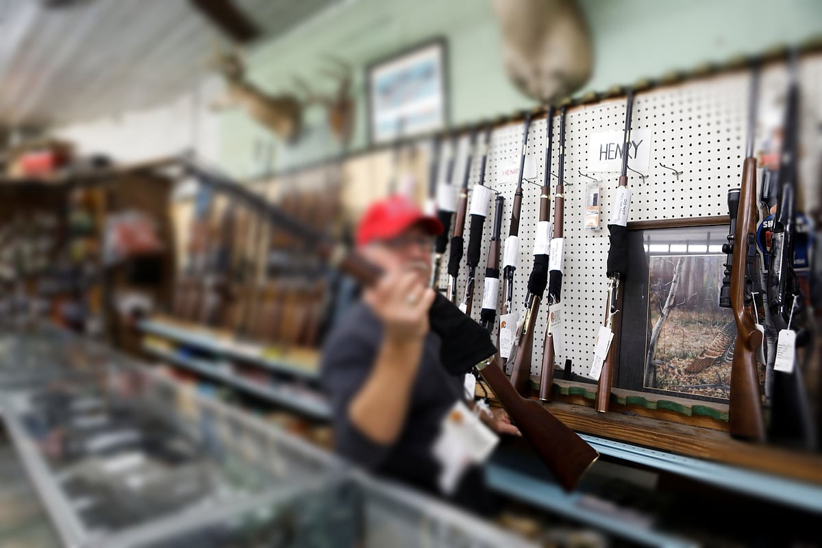 US president Donald Trump supporter Richard Albrecht, a sales associate at Nordic Gun & Pawn, displays a shotgun for a customer, in Wildwood