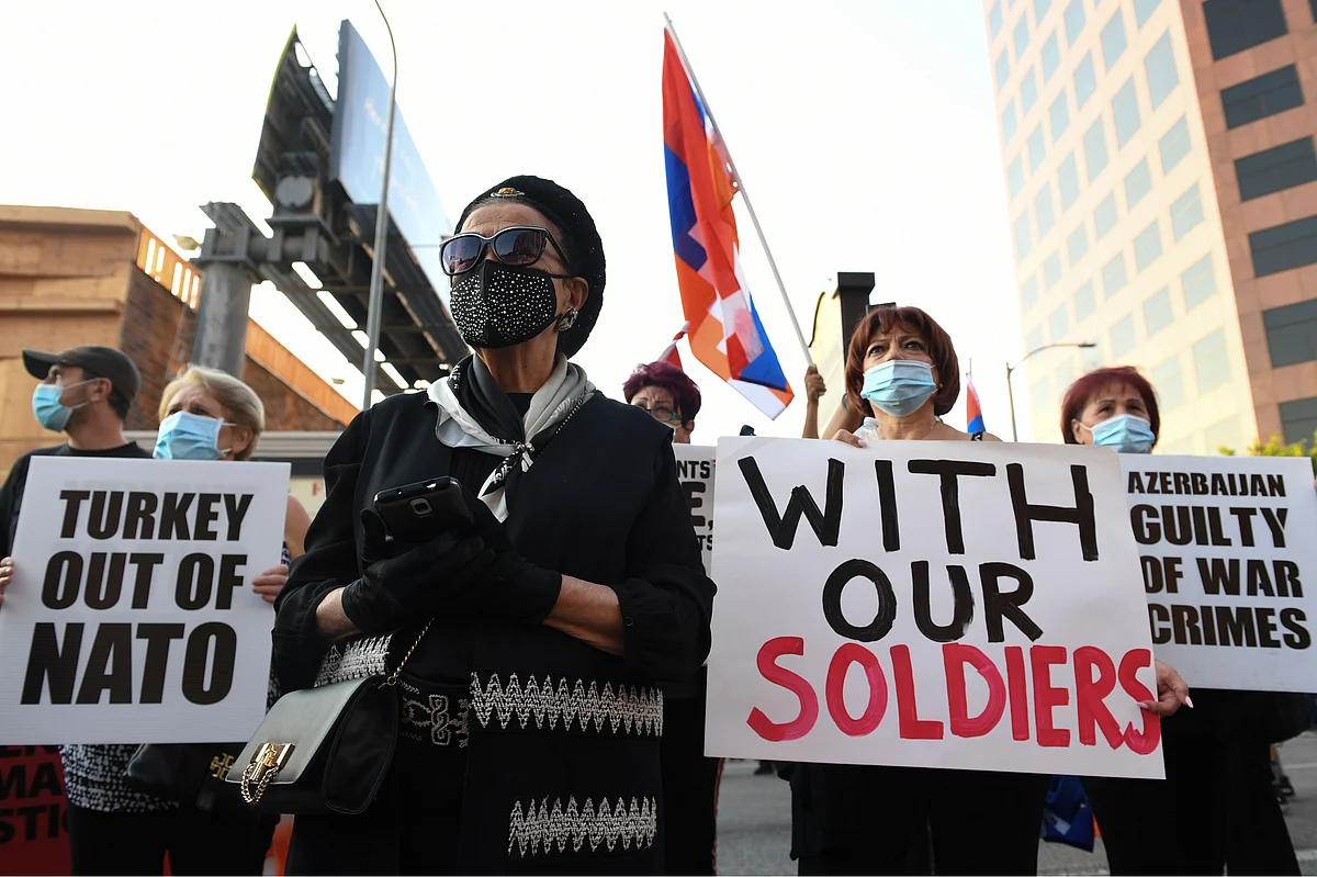 People hold signs as they stand with members of the Armenian Youth Federation (AYF) as they hold a protest outside the Azerbaijani Consulate General in Los Angeles on 30 September 2020 to protest what they call Azerbaijan's "aggression against Armenia and Artsakh"