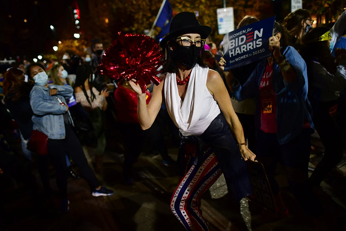 A woman dances after Democratic presidential nominee Joe Biden overtook president Donald Trump in the Pennsylvania general election vote count across the street from where ballots are being counted, three days after the 2020 US presidential election, in Philadelphia, Pennsylvania, US. 6 November, 2020