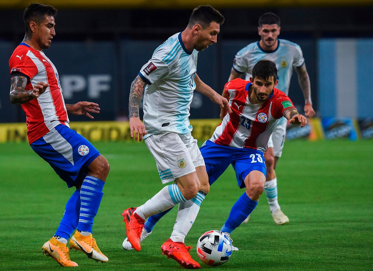 Argentina's Lionel Messi (C) controls the ball next to Paraguay's Mathias Villasanti (R) during their closed-door 2022 FIFA World Cup South American qualifier football match at La Bombonera Stadium in Buenos Aires on 12 November 2020