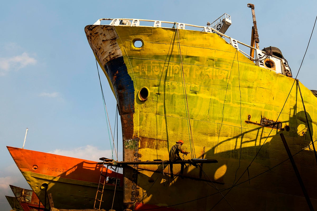In this picture taken on 16 November 2020 a dockyard worker welds a hull section of a ship structure on the banks of the Buriganga River in Char Kaliganj on the outskirts of Dhaka