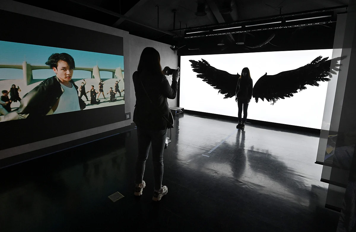 Fans of South Korean K-pop boy band BTS take souvenir pictures at a BTS pop-up store in Seoul on 19 November 2020 ahead of the super group's new album launch this week.