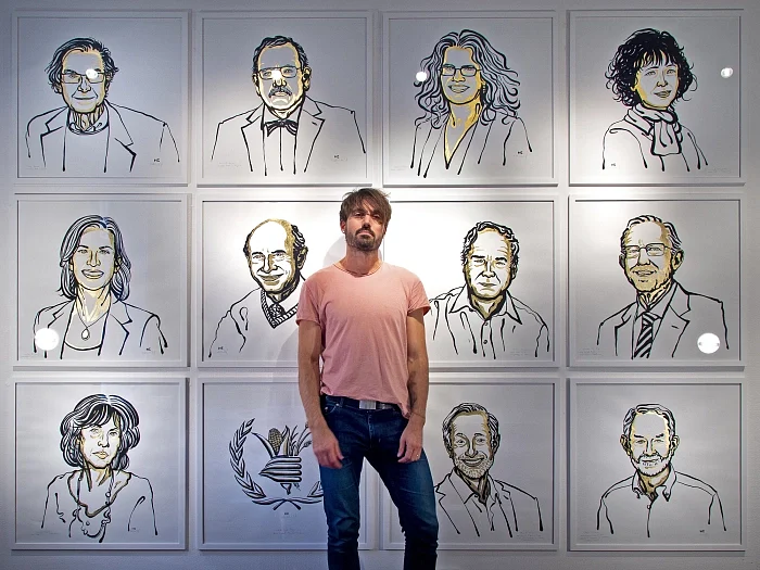 Artist Niklas Elmehed with his portraits of the 2020 Nobel Prize winners