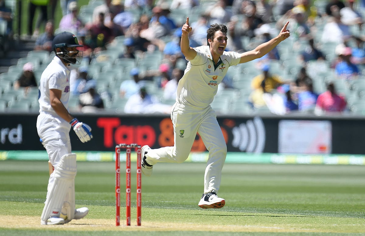 Australian bowler Pat Cummins reacts after dismissing Indian captain Virat Kohli (L) for 4 runs on day 3 of the first test match between Australia and India at Adelaide Oval, Adelaide, Australia, on 19 December 2020