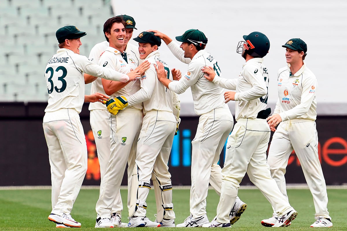 Australia's paceman Pat Cummins (2nd L) celebrates his wicket of India's Cheteshwar Pujara with teammates on the second day of the second cricket Test match between Australia and India played at the MCG in Melbourne on 27 December 2020