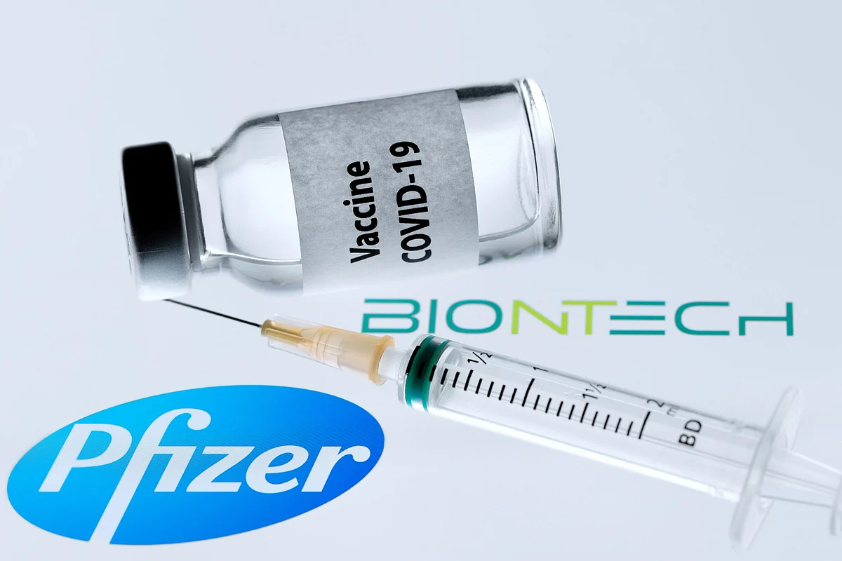In this file photo taken on 23 November 2020 is pictured a bottle reading "Vaccine Covid-19" next to US pharmaceutical company Pfizer and German biotechnology company BioNTech logos