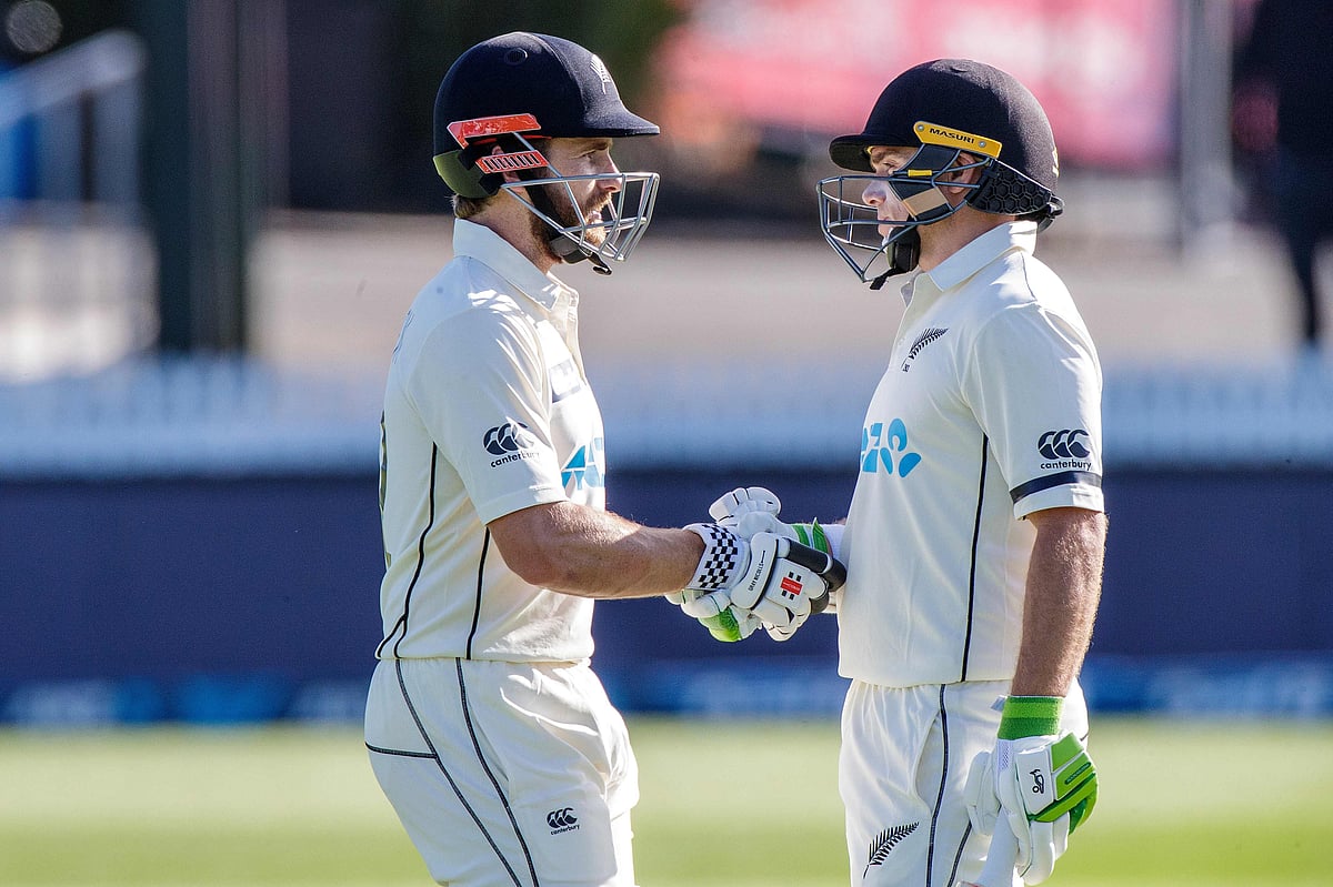New Zealand's captain Kane Williamson (L) speaks with Tom Latham during the first day of the first Test cricket match between New Zealand and West Indies at Seddon Park in Hamilton on 3 December 2020