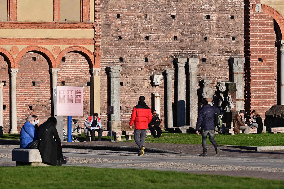 Milanese wearing protective mask enjoy the nice winter weather in the interior courtyard of the Sforza castle in centeral Milan on 13 January