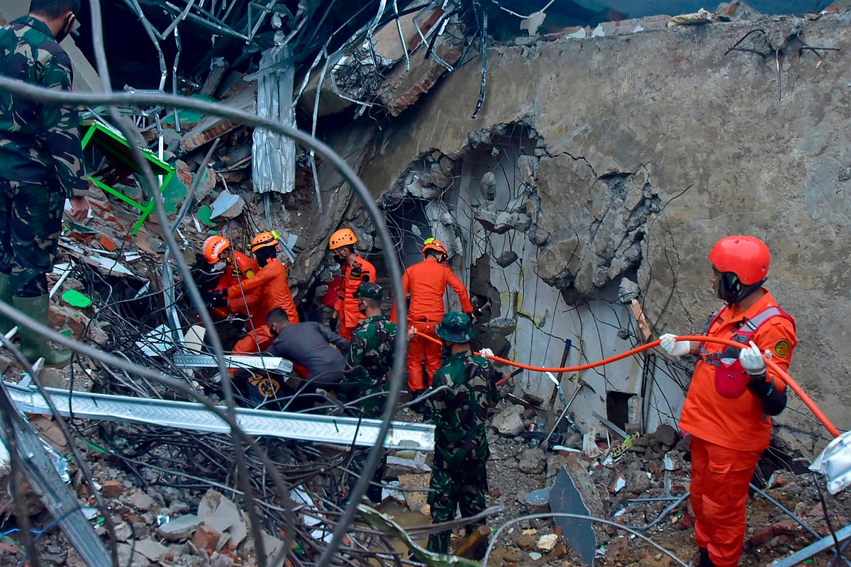 Rescuers search for survivors at a collapsed building in Mamuju on 15 January, 2021, after a 6.2-magnitude earthquake rocked Indonesia's Sulawesi Island