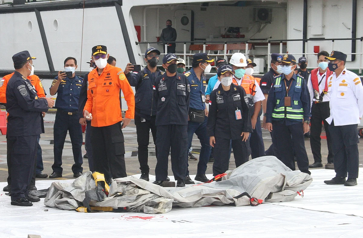 Rescue workers inspect recovered debris at the port in Jakarta on 10 January 2021, during the search operation for Sriwijaya Air flight SJY182 which crashed after takeoff from Jakarta on 9 January