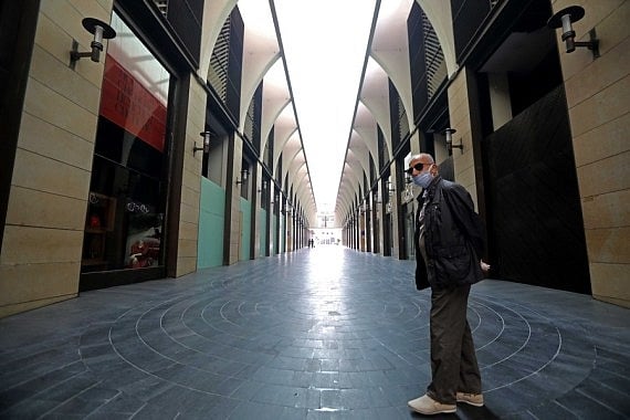 A man wearing a face mask stands in front of closed shops in Beirut, Lebanon, on 14 November 2020