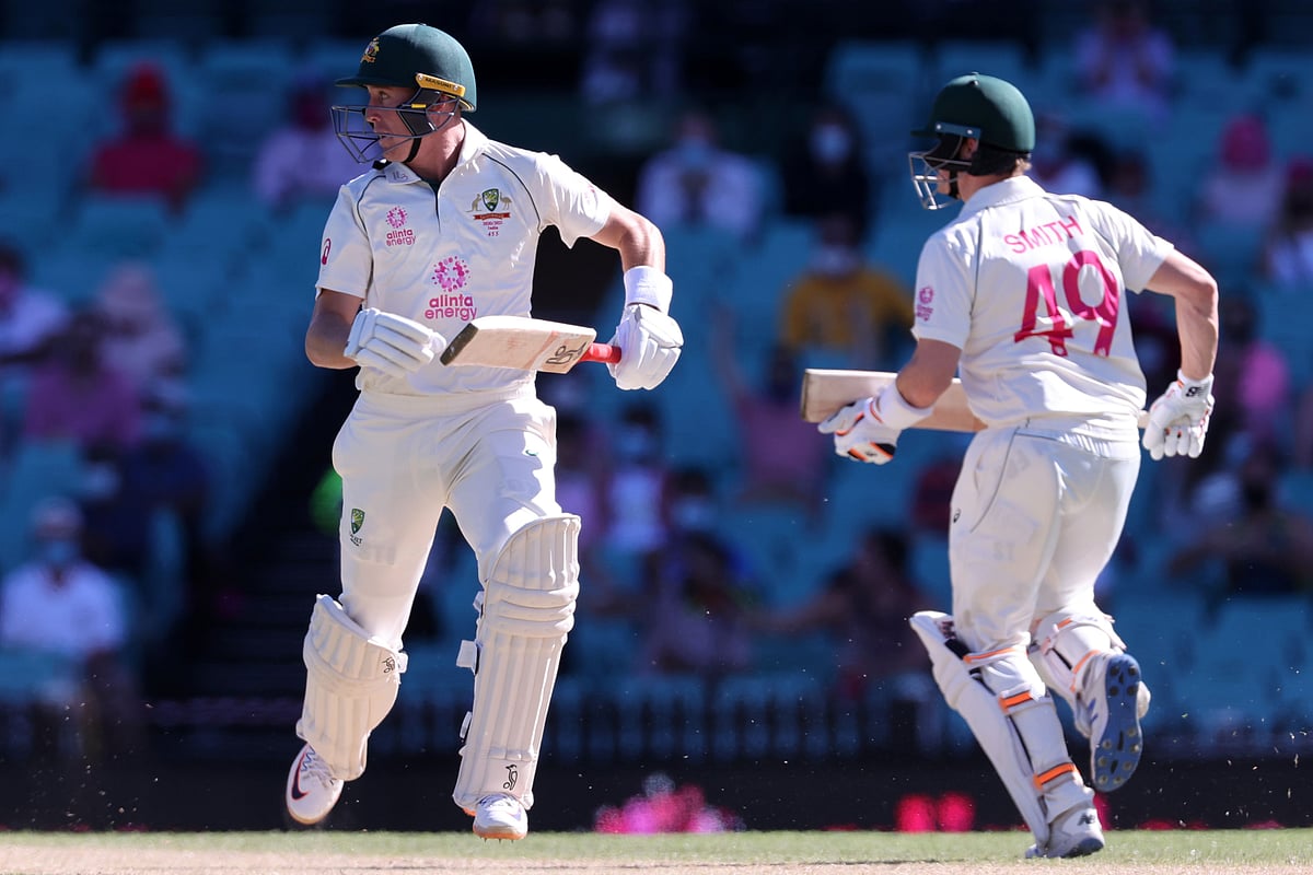 Australia's Marnus Labuschagne (L) and Steven Smith run between the wickets on the third day of the third cricket Test match between Australia and India at the Sydney Cricket Ground (SCG) in Sydney on 9 January 2021