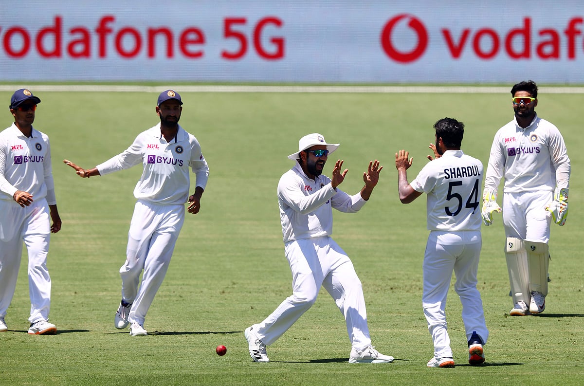 India's paceman Shardul Thakur (2nd R) celebrates his wicket of Australia's captain Tim Paine with teammate Rohit Sharma (C) on day two of the fourth cricket Test at The Gabba in Brisbane on 16 January 2021