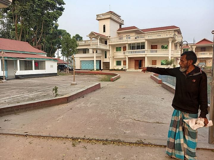 Altu Miah points out his land within the boundary wall of MP Moazzem's 'Haor Bungalow' in Dharampasha upazila of Sunamganj