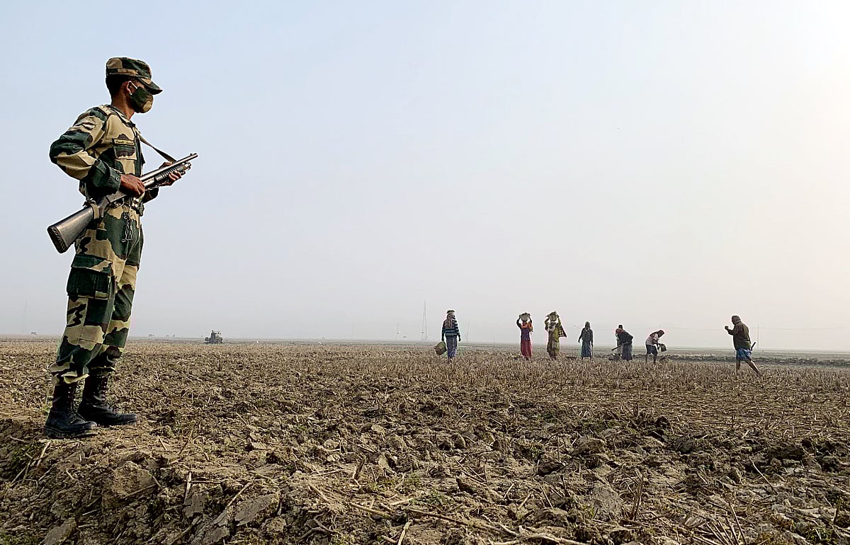A BSF personnel stands guard near the border area where the Government of India plans to fence the borders with Bangladesh, in Sonamura on 3 February 2021