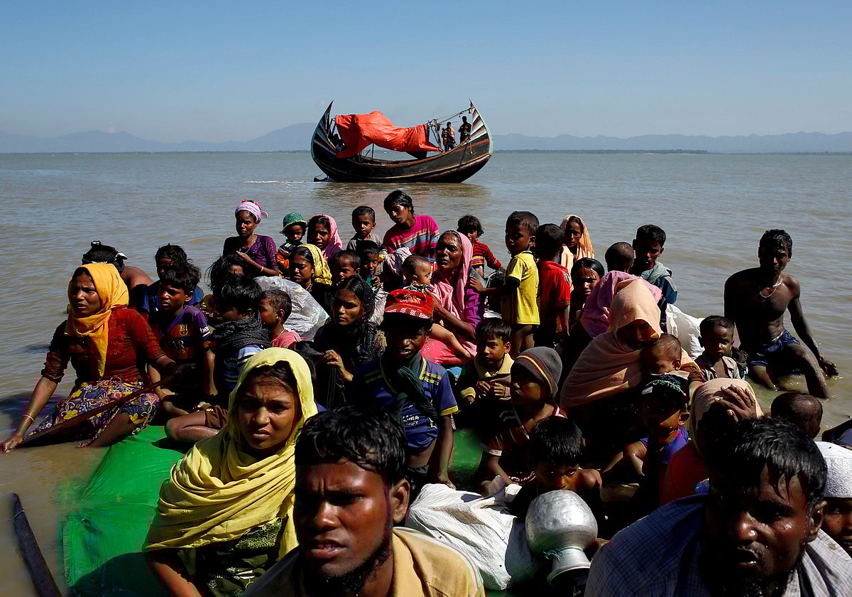 Rohingya refugees sit on a makeshift boat as they get interrogated by the Border Guard Bangladesh after crossing the Bangladesh-Myanmar border, at Shah Porir Dwip near Cox's Bazar, Bangladesh on 9 November 2017