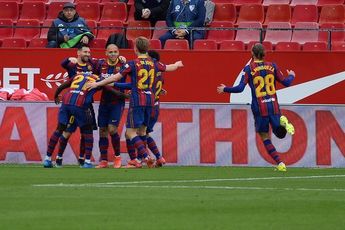 Barcelona's Argentinian forward Lionel Messi (L) celebtates with teammates after scoring during the Spanish league football match between Sevilla FC and FC Barcelona at the Ramon Sanchez Pizjuan stadium in Seville on 27 February 2021