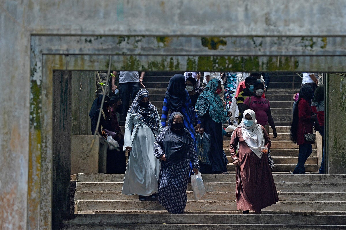 Burqa clad Muslim women climb down a flight of stairs at a zoological park on the outskirts of Colombo on 14 March, 2021
