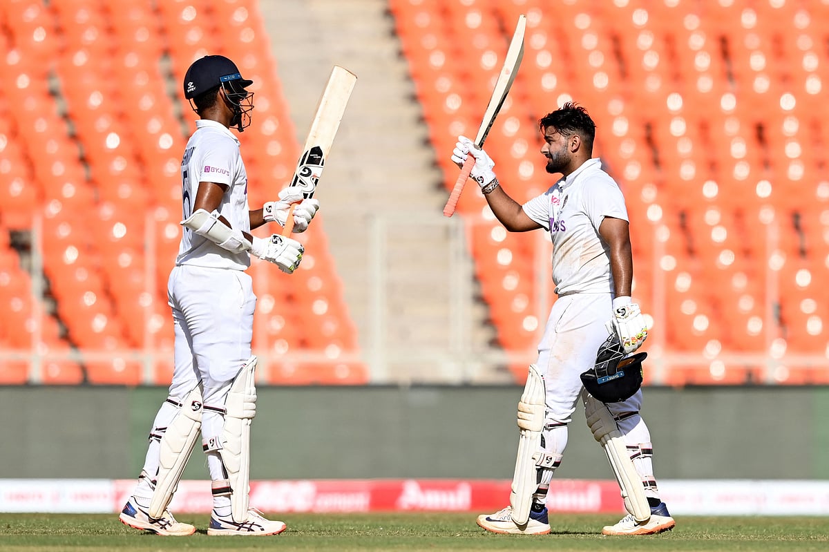 India's Rishabh Pant (R) celebrates after scoring a century (100 runs) as teammate Washington Sundar watches on the second day of the fourth Test cricket match between India and England at the Narendra Modi Stadium in Motera on 5 March, 2021
