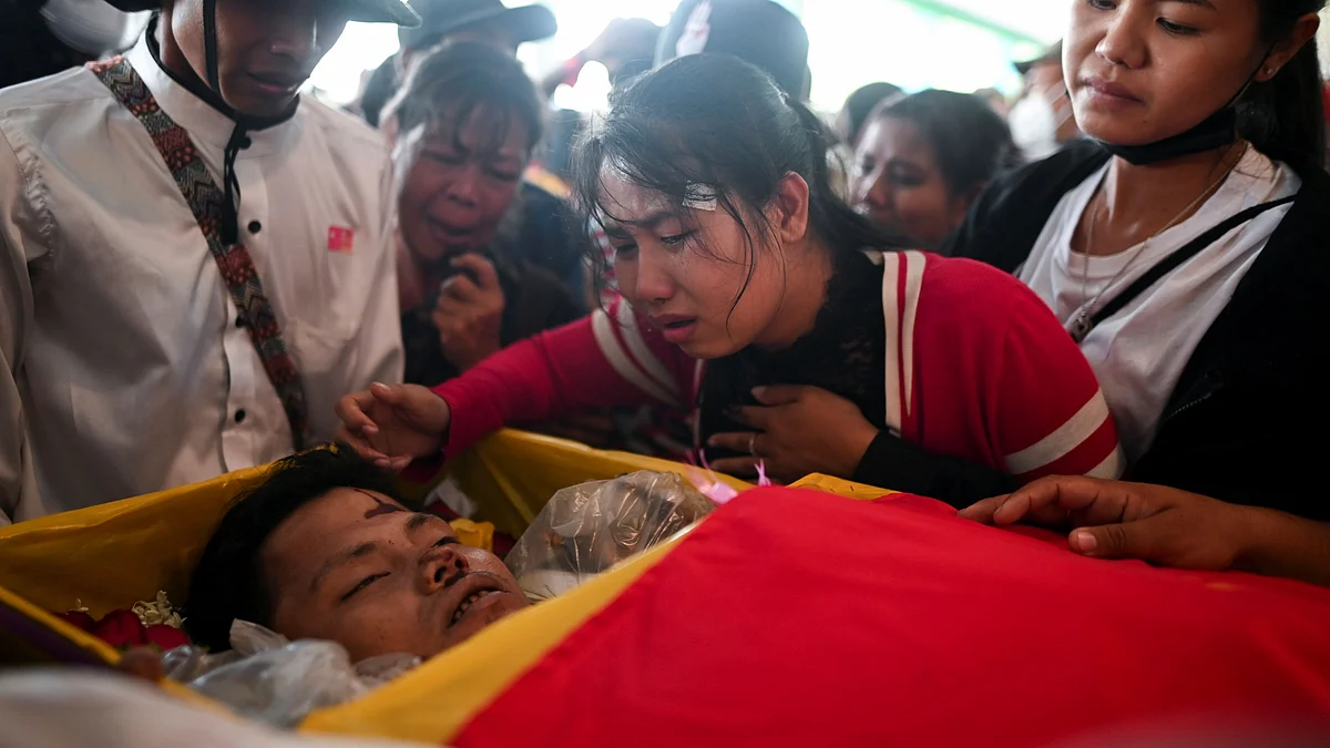 A woman reacts next to the body of a victim who was shot dead during the anti-coup protest, in a cemetery at the outskirts of Yangon, Myanmar, on 5 March 2021