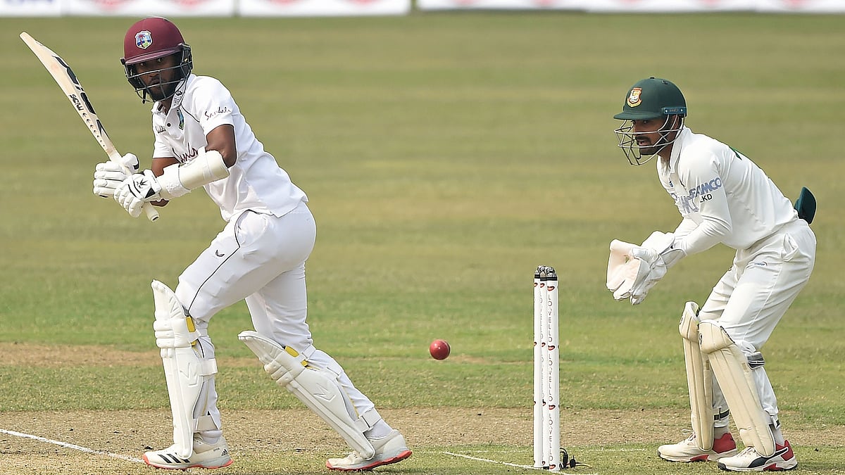 West Indies' captain Kraigg Brathwaite (L) plays a shot as Bangladesh's wicketkeeper Liton Das watches during the first day of the second Test cricket match between West Indies and Bangladesh at the Sher-e-Bangla National Cricket Stadium in Dhaka on 11 February 2021