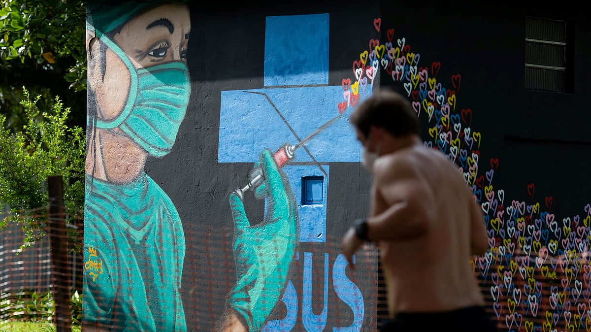 A man runs next to a graffiti near Gonzaga beach, after beaches in the coast of the state of Sao Paulo got closed as a restrictive measure to contain the outbreak of the coronavirus disease (COVID-19), in Santos, Sao Paulo state, Brazil on 26 March 2021
