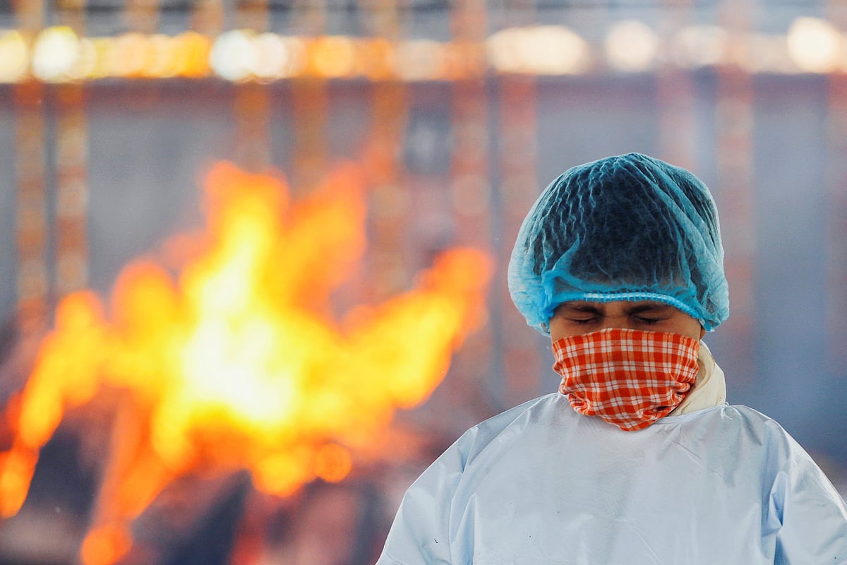 A boy reacts next to the body of his father, who died from the coronavirus disease (COVID-19), at a crematorium in New Delhi, India 24 April, 2021