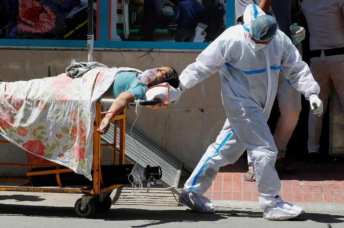 A health worker wearing personal protective equipment (PPE) carries a patient suffering from the coronavirus disease (COVID-19) outside the casualty ward at Guru Teg Bahadur hospital, in New Delhi, India, 24 April, 2021