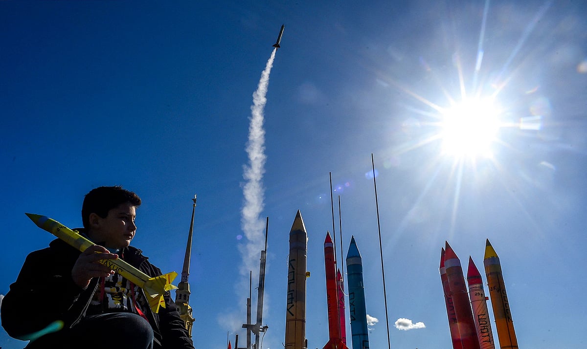 A young participant holds a rocket as another launches during a display of model rockets near The Peter and Paul Fortress in Saint Petersburg on 11 April, during a celebration of the 60th anniversary of Russia's Yuri Gagarin's first manned flight into space
