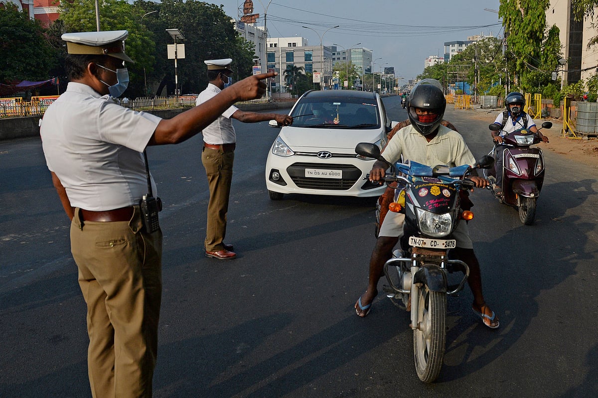 Police stop commuters to check their identity documents at a temporary check post during the Sunday lockdown wherein only people catering to essential services were allowed to ply as a preventive measure against the spread of the Covid-19 coronavirus in Chennai on 25 April