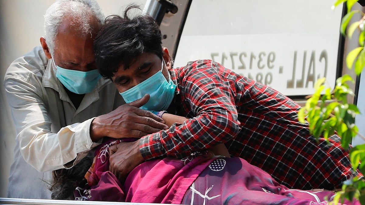 Relatives mourn over the body of a woman, who died from the coronavirus disease, outside Lok Nayak Jai Prakash Narayan Hospital (LNJP), one of India's largest facilities for Covid-19 patients only, in New Delhi, India, on 22 April 2021